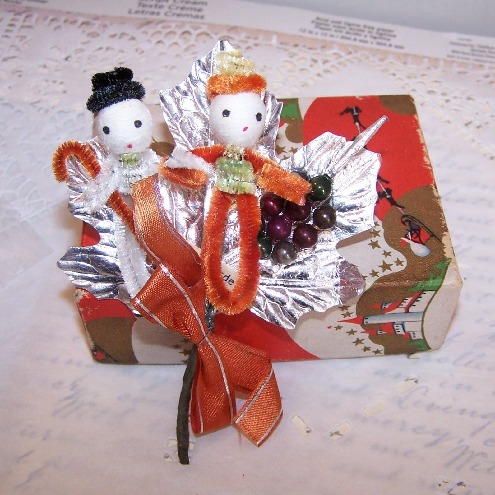 Christmas pick or package adornment Made in Japan. 2 chenille pixies, mercury glass beads, silver foil and red ribbon make up the creation.  Vintage patina. 