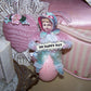 Handmade Victorian Revival Spring chenille ornament. A baby girl sits on a sparkly Pink Egg and holds a sign that reads OH HAPPY DAY. All occasion gift idea!