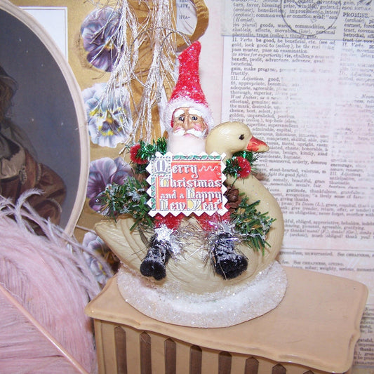 OOAK Chenille Santa Claus riding an upcycled Art Deco era celluloid swan.  Sentiment is "Merry Christmas and a Happy New Year." 4-3/4" x 3-1/2". Lightweight.