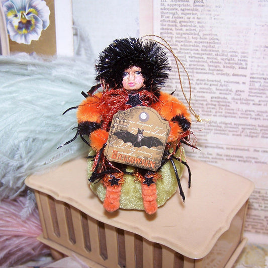 Mixed media OOAK Halloween ornament of a little girl carrying a Halloween sign while sitting on a velvet pumpkin.  Handpainted face.  3-3/4" x 2-1/2"