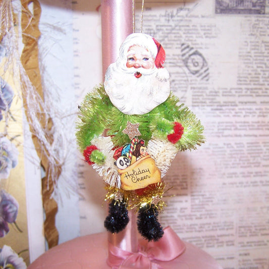 OOAK Santa Claus Christmas ornament. HOLIDAY CHEER!  Made of chenille, Santa sports a 1950s Christmas sticker face and holds a Christmas wreath. 4" x 2.5"