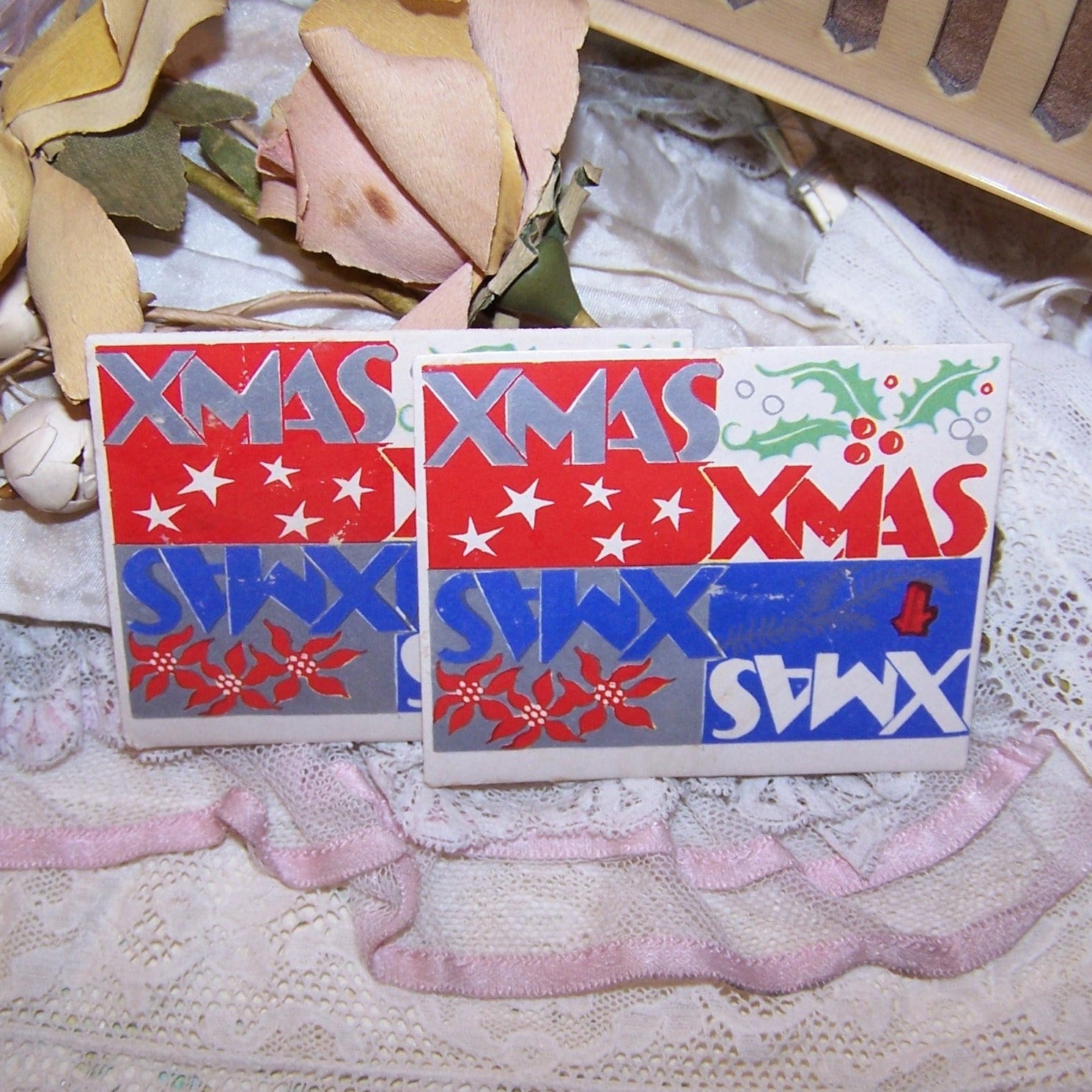 7 Christmas Stickers / Seals in a red, white & blue patriotic coloring. Rectangular in shape, graphics include holly, poinsettias and stars. Unknown maker.