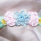 Ribbonwork spray of 5 florals. Powder Blue satin center while the shoulder blossoms are Baby Pink satin then French Yellow Ombre. Size is 3-3/4" x 1-3/16".