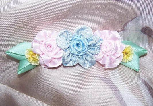 Ribbonwork spray of 5 florals. Powder Blue satin center while the shoulder blossoms are Baby Pink satin then French Yellow Ombre. Size is 3-3/4" x 1-3/16".