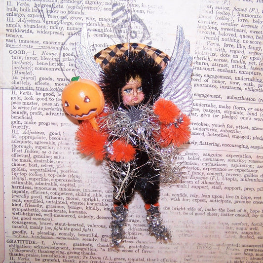 With silver Dresden paper wings, my OOAK little girl Trick or Treater Halloween ornament carries a plastic Jack o Lantern pick. 5" x 2-1/2" approx. 