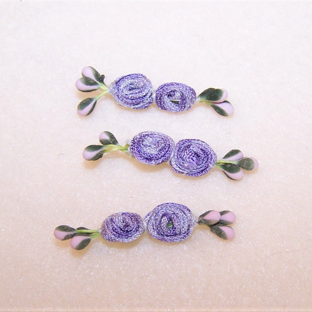 With a pair of center rounds made of coiled ombre ribbon, this set/3 hand sewn florals have pink and green sugar pips. Length is 1-1/2"; width is 1/4". 