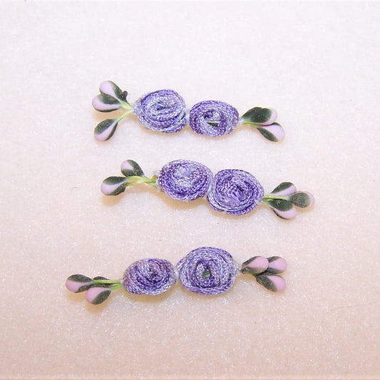 With a pair of center rounds made of coiled ombre ribbon, this set/3 hand sewn florals have pink and green sugar pips. Length is 1-1/2"; width is 1/4". 