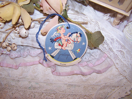 Art Deco unused Christmas Gift package tie on.  Image of an angel riding a rocking horse. Unused condition - vintage patina to the paper. Unknown maker. 