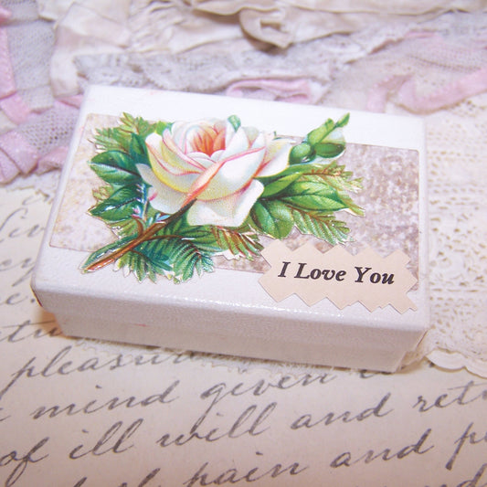 Upcycled paper box for a small item.  Lid displays an Antique Victorian die cut of a white rose.  Sentiment is I LOVE YOU. 2-1/2" x 1-3/4"; depth is 15/16". 