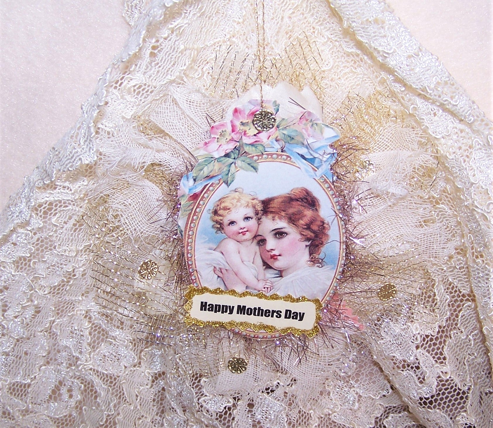 Victorian Revival Mother's Day ornament or decoration.  A puffy fabric oval holds the image of a Mother and Child as well as cream fabric with gold highlights.