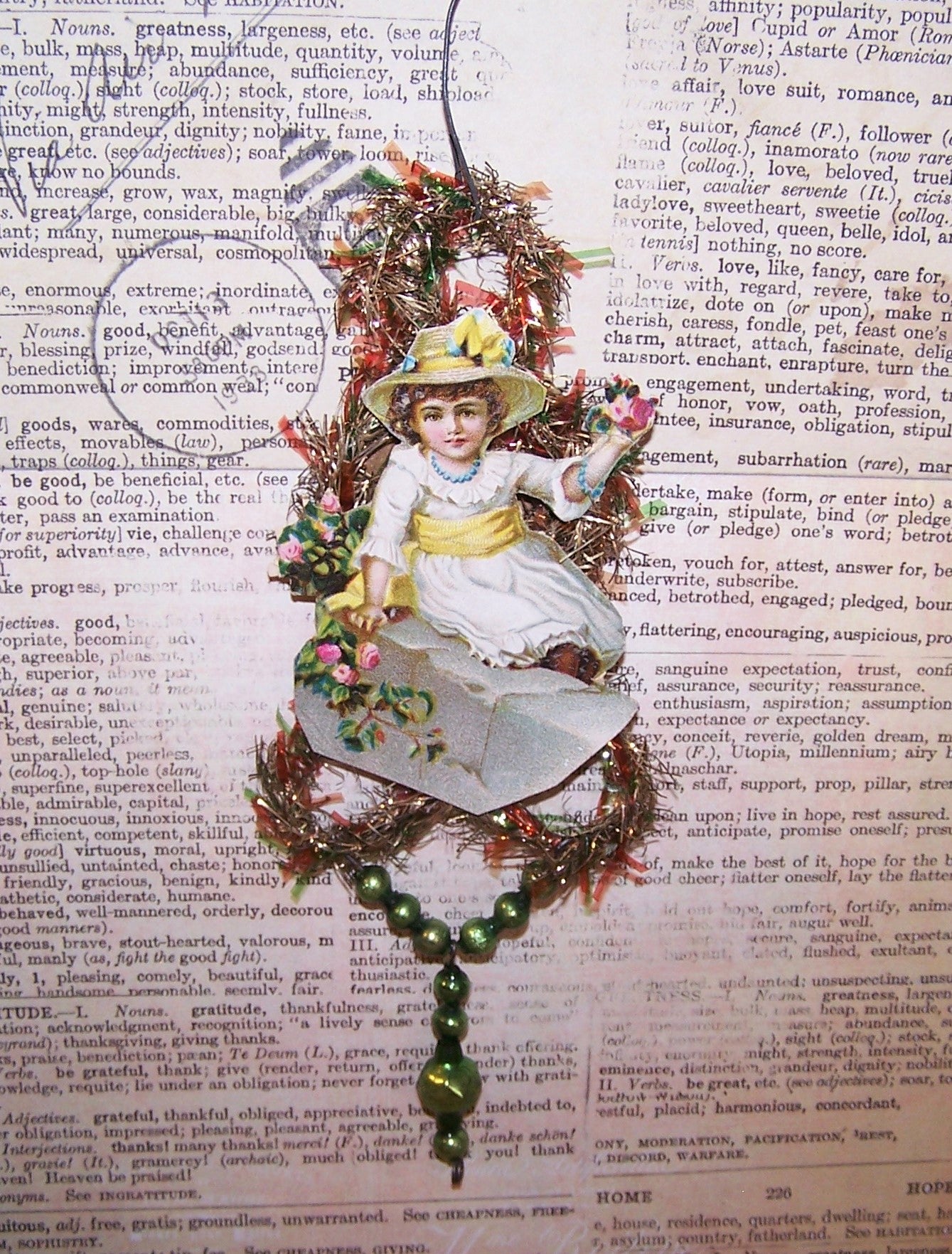 Victorian Revival handcrafted tinsel and mercury glass Christmas ornament.  Die cut of a Lady in white holding flowers is the focal point. Light but lengthy.