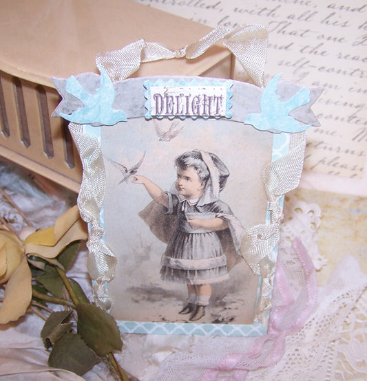 Made of paper & ribbon, here's an everyday ornament or gift tag. Front graphic is an Antique Victorian image of a little girl with a bird.  Sentiment is DELIGHT. 
