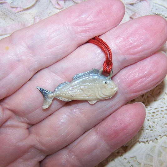 With its original red cord, here's a vintage Cracker Jack charm (plastic) of a grey/cream toned fish. 1-1/4" long x 5/8" high. Very nice condition.