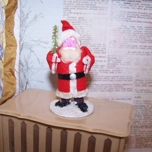 Vintage handcrafted Made in Japan Santa Claus Christmas decoration.  Pink clay face, Santa wears felt-like clothing and carries a sprig of green.