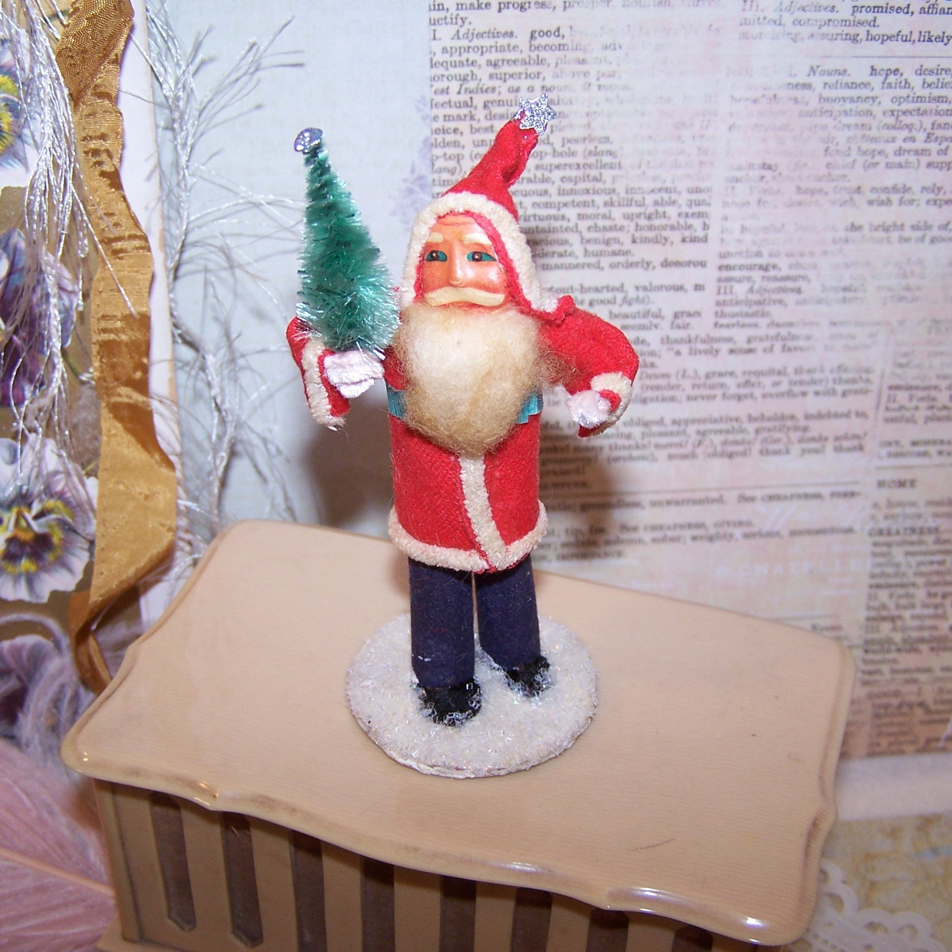 Vintage 3.5" Made in Japan Santa Claus Christmas figure decoration.  Paper face, Santa wears felt-like clothing and carries a tree of green chenille. Mica base.