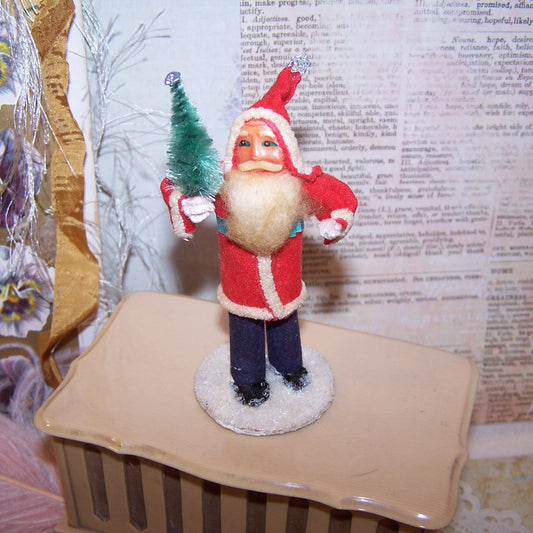 Vintage 3.5" Made in Japan Santa Claus Christmas figure decoration.  Paper face, Santa wears felt-like clothing and carries a tree of green chenille. Mica base.