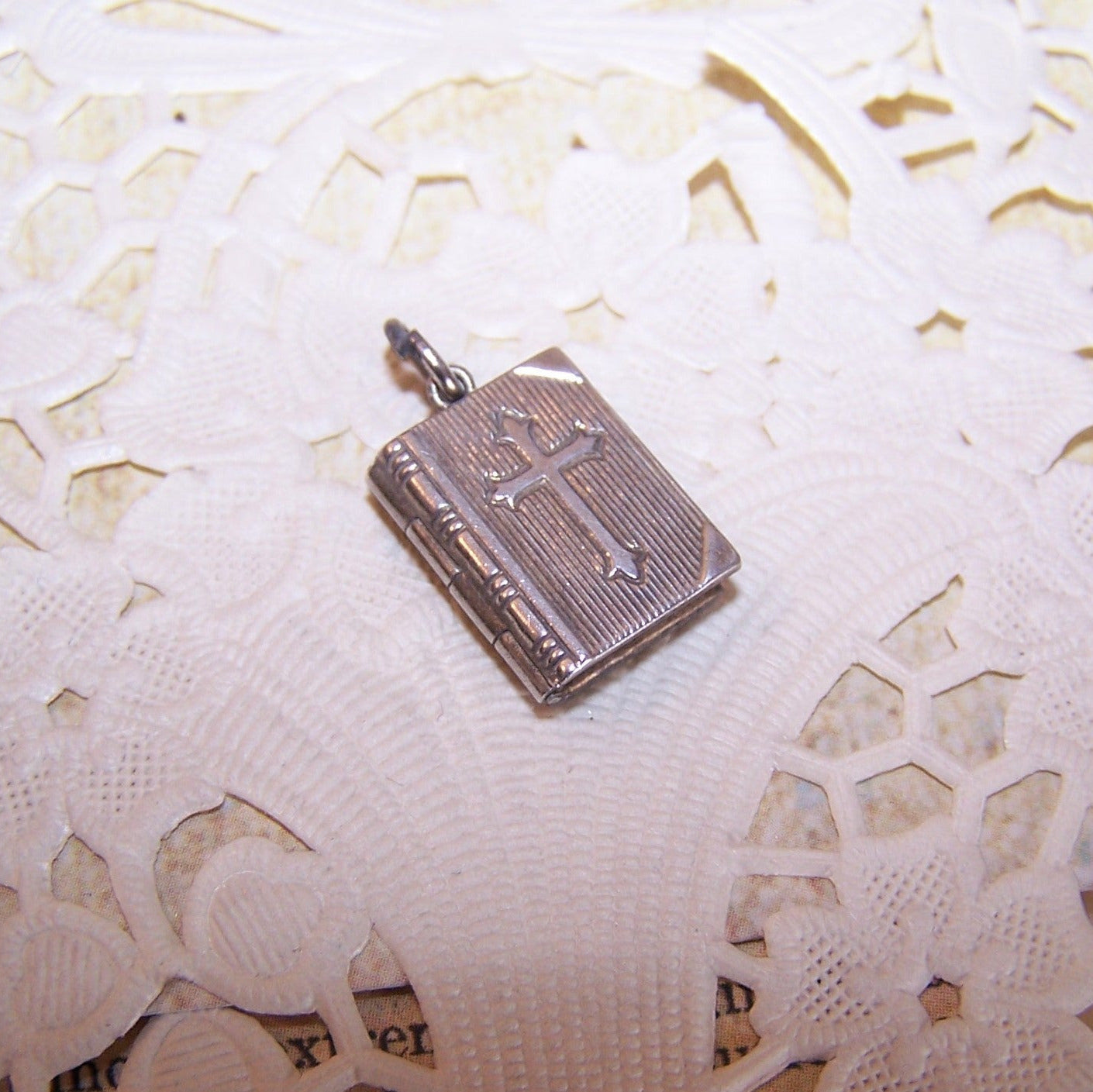 JMF & Co Sterling Silver book locket charm in the shape of the Holy Bible. Lords Prayer (under plastic) in its entirety on the inside.  9/16" x 7/16". 2 grams. 