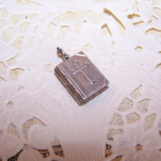 JMF & Co Sterling Silver book locket charm in the shape of the Holy Bible. Lords Prayer (under plastic) in its entirety on the inside.  9/16" x 7/16". 2 grams. 