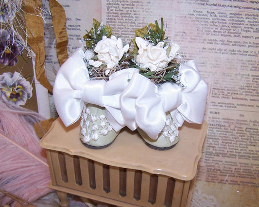 Vintage decorated doll shoe ornament, gift or table favor. Buff with bridal white and green accents - satin ribbon, lace and paper flowers. 3-1/2" x 4". 